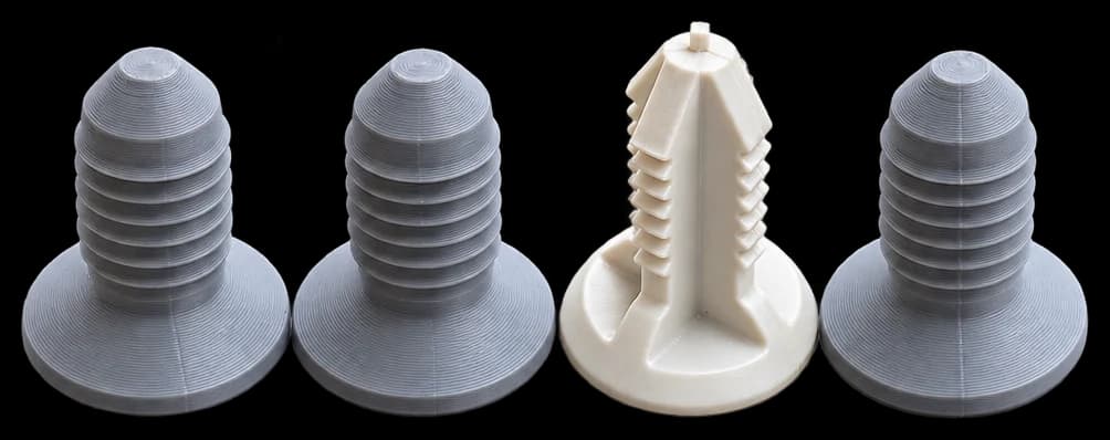Four push-in trim clips: three grey printed copies and one white original